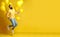 Laughing jumping man with balloons on a yellow background