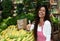 Laughing latin american saleswoman at farmers market with corn a