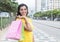 Laughing latin woman with yellow shirt after shopping in city