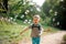 Laughing little boy with soap bubbles in summer park on sunny da