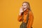 Laughing little kid girl 12-13 years old in turtleneck, jumpsuit isolated on orange yellow background. Childhood