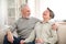 Laughing loving aged couple relaxing on cozy couch at home