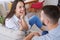 Laughing male and female chatting while sitting on sofa