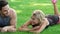 Laughing man and woman flirting in park. Sport couple lying on green grass