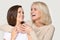 Laughing mature mother embracing happy millennial daughter spending time together