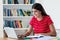 Laughing mexican female student learning on computer