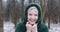 Laughing middle aged woman in winter forest closeup. Cheerful woman with headband in hood of green jacket from eco fur.