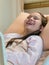 Laughing mixed race tween girl in hospital bed