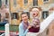 Laughing mother holding happy daughter sitting along canal edge