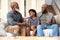 Laughing Multi-Generation Male Family Hanging Out On Sofa At Home Talking Together