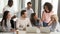 Laughing multiracial office workers sitting in boardroom having funny break