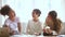 Laughing multiracial students girls enjoy studying together sitting on couch