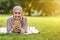 Laughing muslim woman using her smartphone, resting in park