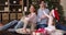 Laughing parents kids messing under Xmas tree in festive mood