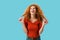 Laughing redhead girl isolated on blue