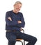 Laughing senior man sitting with arms crossed