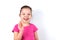 Laughing six years old little beautiful girl with greeting gesture raised hand on white background. Childhood, goodwill, greeting