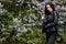 Laughing and smiling beautiful happy artistic young model girl with long hair in summer lilac garden with flowers posing