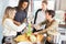 Laughing students prepare salad together in shared kitchen