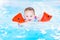 Laughing toddler girl having fun in swimming pool