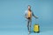 Laughing traveler tourist man in yellow casual clothes with photo camera, suitcase isolated on blue background. Male