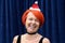 Laughing vivacious redhead in a Santa Hat