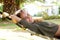 Laughing woman lying in hammock in front of palm tree