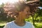 Laughing woman twirling her curly hair outside in a park