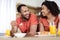 Laughing young african american wife and husband in same t-shirts have breakfast and enjoy communication