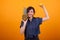 Laughing young beautiful woman with tropical fruits in studio over yellow background