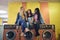 Laughing young girlfriends sitting on washing machines at a laundromat