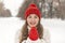 Laughing young woman in knitted red hat and mittens,winter park. Woman warms up in woolen clothes outdoors, cold weather