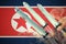 Launch of nuclear missiles. North Korean flag in background. 3D rendered illustration