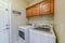 Laundry appliances inside small and functional utility room of residential home