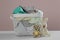 Laundry basket with different children`s clothes and toys on white table