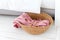 Laundry basket with pink towel. Interior of white stylish room with laundry basket.