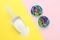 Laundry capsules and scoop of washing powder on color background, flat lay