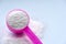 Laundry detergent powder and pink plastic scoop on blue