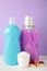 Laundry detergents with washing powder and capsules on purple background