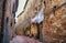 Laundry dried on a rope outside a brick house on narrow street of town of Tuscany