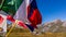 Laundry and flags in mountains. Clothes hanging to dry, flags waving in wind and blue sky in summer in Aosta Valley in Italy