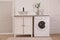 Laundry room interior with washing machine and stylish vessel sink on countertop