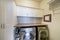 Laundry room with stainless laundry machines below the wooden desk