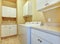 Laundry room with white cabinets and yellow walls.