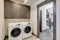 Laundry room with white wahser and dryer and dark brown wood cabinets