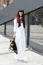 Laura Comolli poses for photographers with white dress and V73 backpack before Costume National fashion show