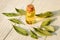 Laurel essential oil in glass bottle and leaves on wooden background, close-up, sunlight. Copy space