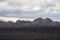 Lava field covered by black ashes before moss covered volcanic v