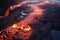 Lava flow emerging from a rock and pouring into a black volcanic landscape. Natural disasters