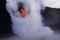 Lava flowing out of cliff suround with white cloud steam